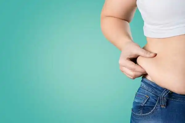 Image of woman pinching her love handles to show weight gain Coleshill